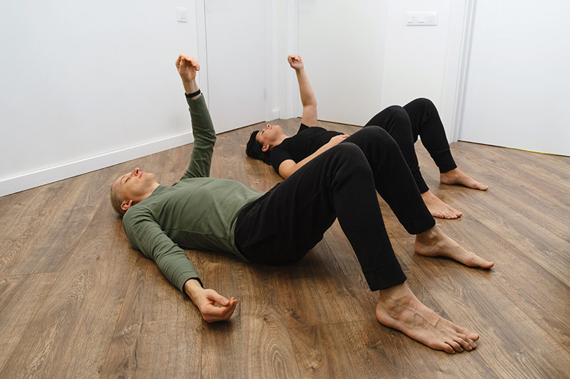 Two people stretching on the floor